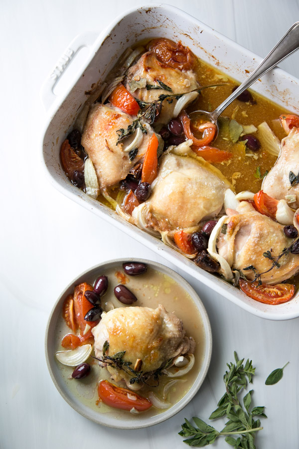 gluten-free baked provencal chicken thighs on a plate next to casserole dish