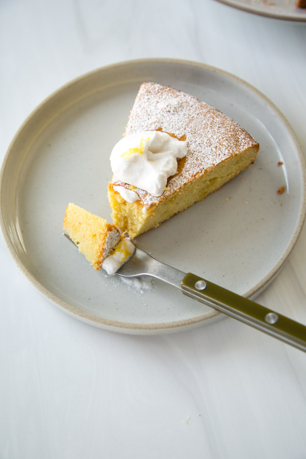 slice of flourless lemon passover cake on plate with dairy-free yogurt