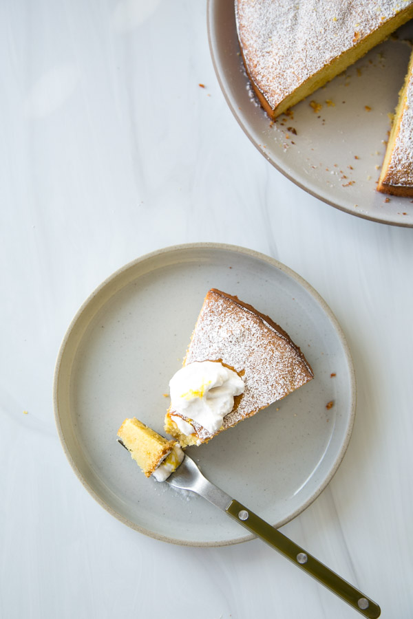 slice of Italian olive oil lemon cake on plate with dairy-free yogurt and fork