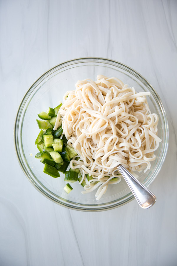 Place cucumber and rice noodles in colander