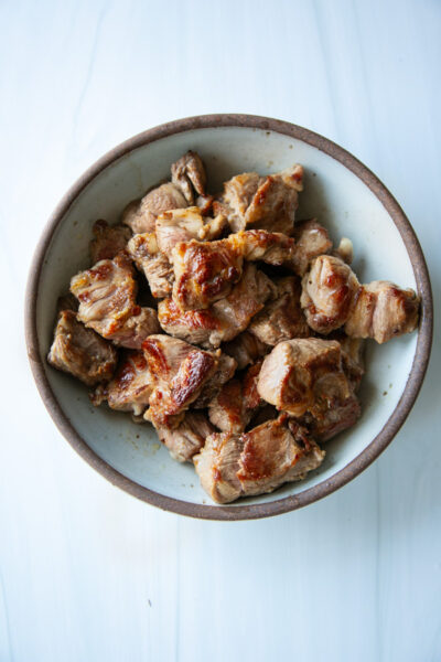 A bowl filled with bite-sized pieces of seared, browned meat.