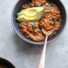 Red lentil curry with spinach in a bowl with spoon
